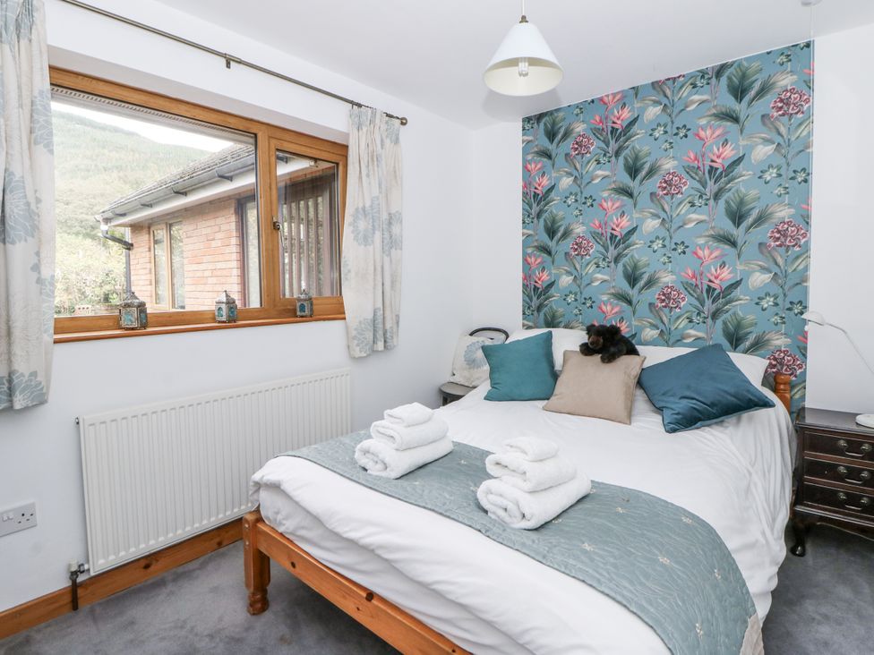 A bedroom with a bed and window at Geryllan in Rhandirmwyn near Llandovery