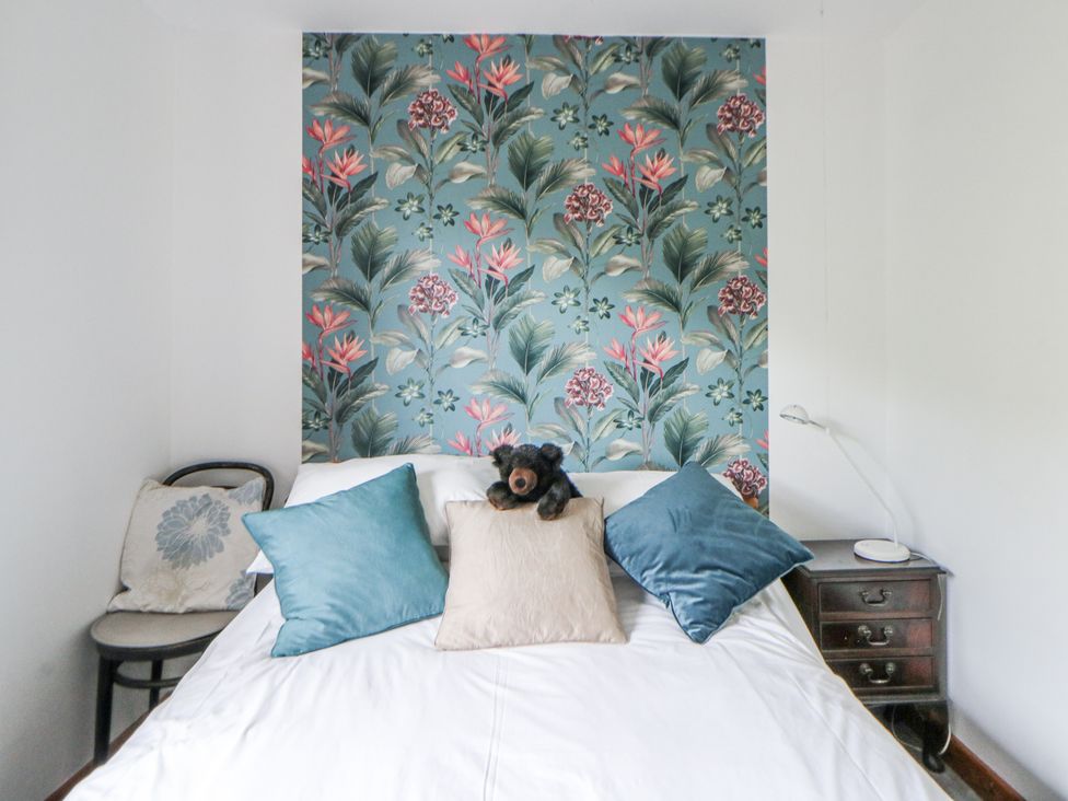 A bedroom with a bed and decorative pillows at Geryllan Rhandirmwyn near Llandovery