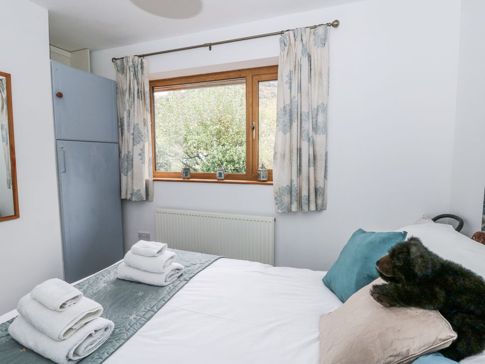 A bedroom with a bed and wardrobe at Geryllan Rhandirmwyn near Llandovery