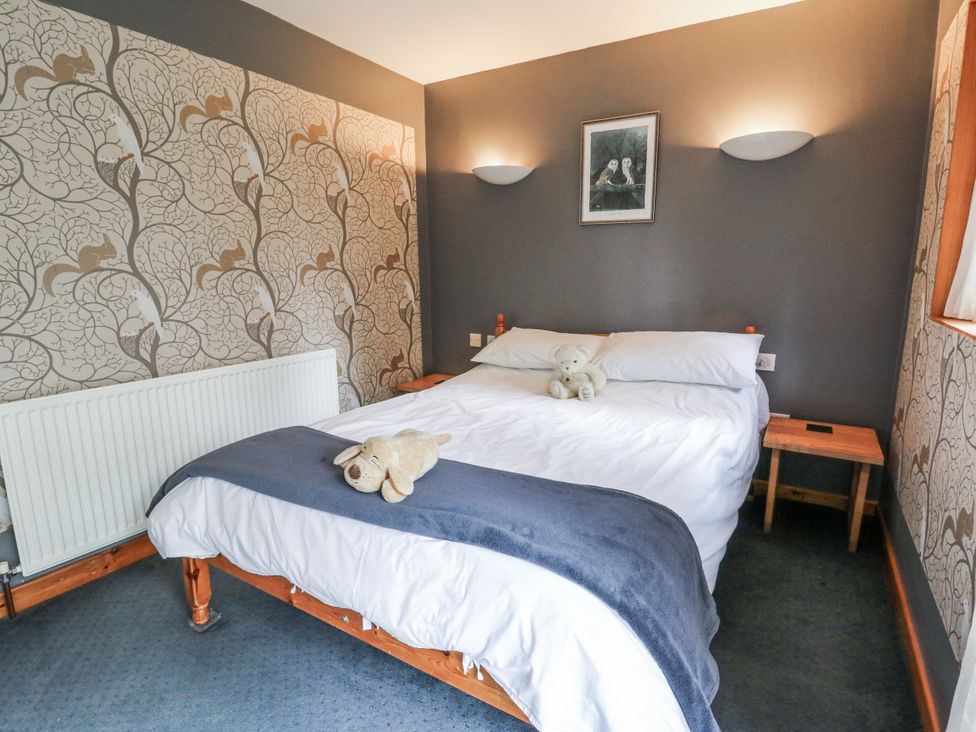 A bedroom with a bed and teddy bear at Geryllan near Rhandirmwyn