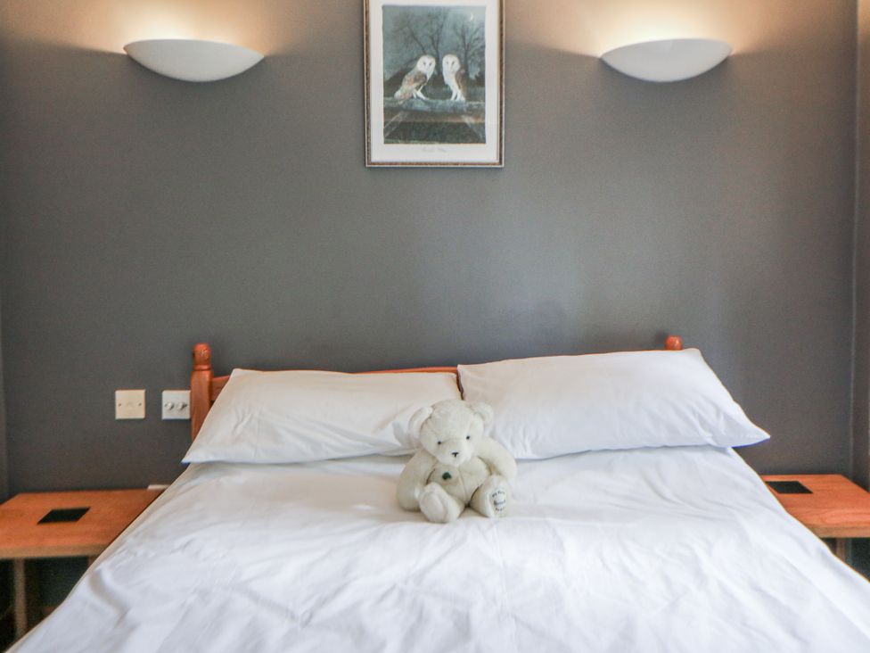 A bedroom with a bed and a teddy bear at Geryllan Rhandirmwyn near Llandovery