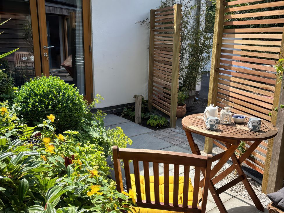 A garden with a wooden table and chairs at The Sidings in Wirksworth