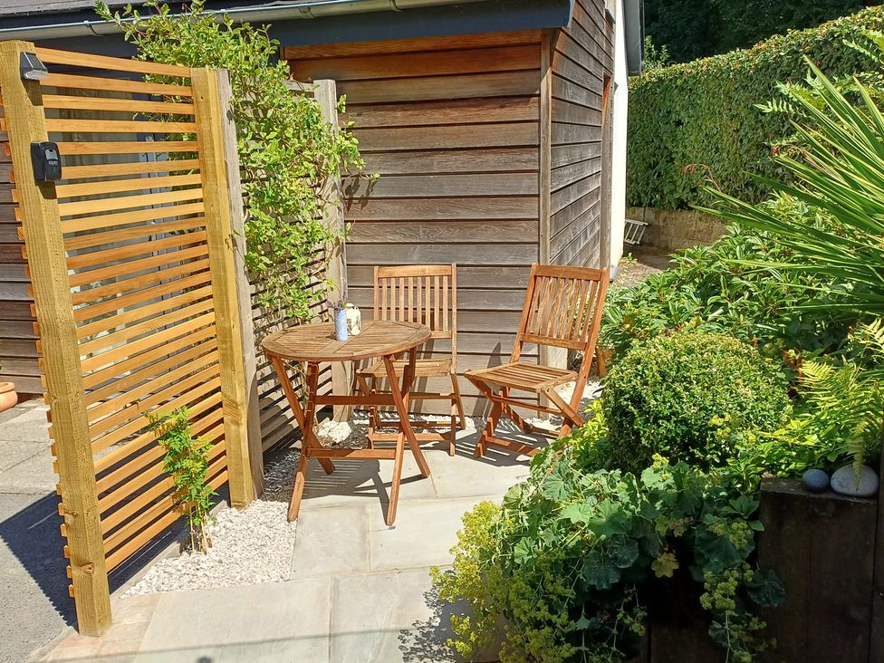 A garden area with a wooden table and chairs at The Sidings in Wirksworth
