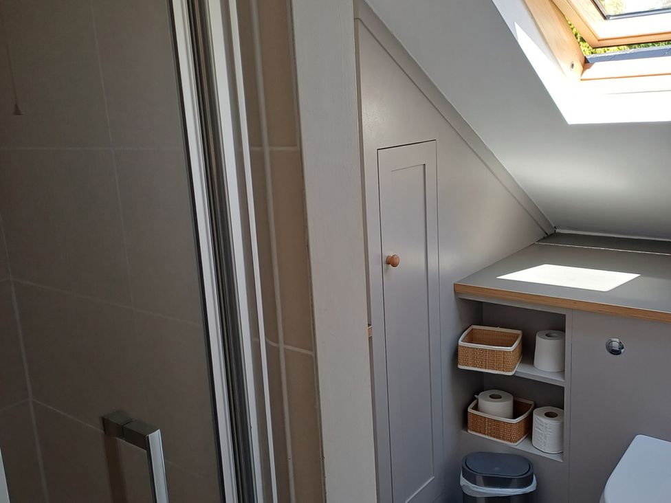 A bathroom with a shower and storage cabinet at The Sidings in Wirksworth