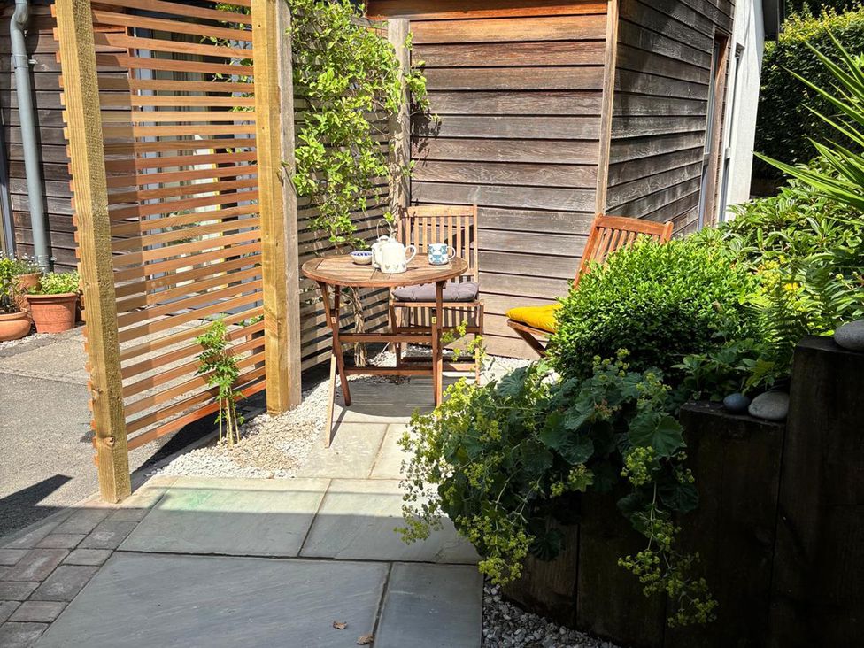 A seating area with a table and chairs surrounded by plants at The Sidings in Wirksworth