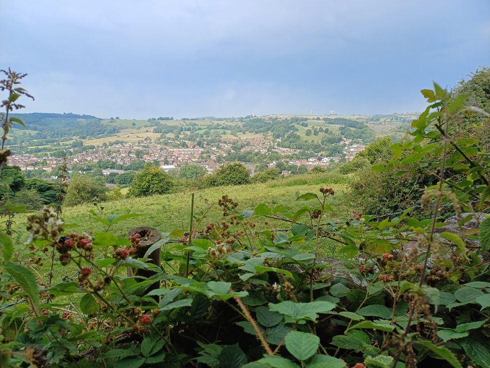 A view of a town surrounded by hills and plants at The Sidings in Wirksworth