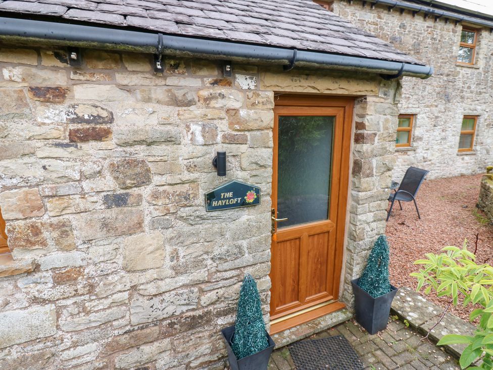 An entrance with a door and sign at The Hayloft in Alston