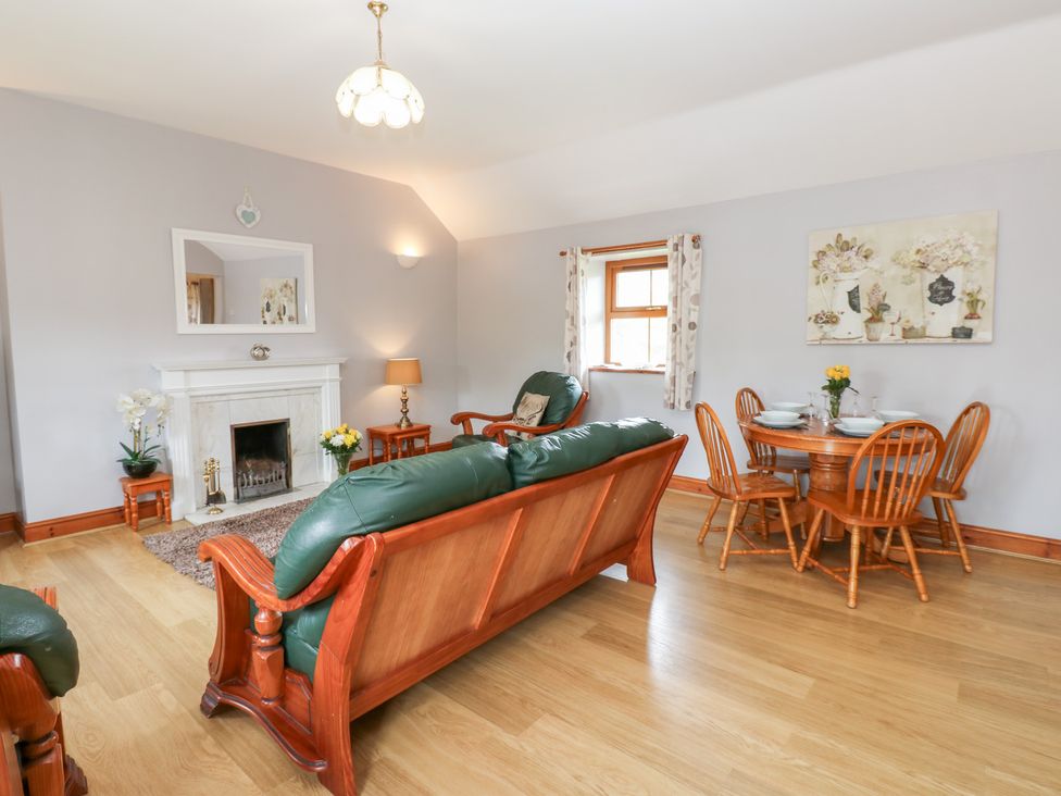 A living room with a sofa and dining table at The Hayloft in Alston