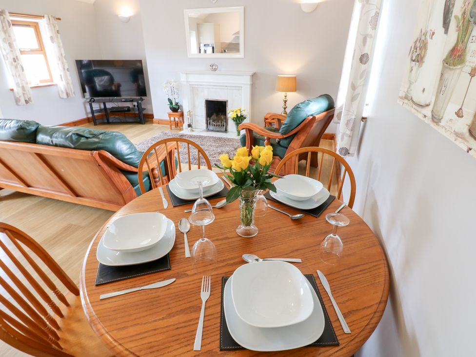 A dining room with a round table set for four at The Hayloft in Alston