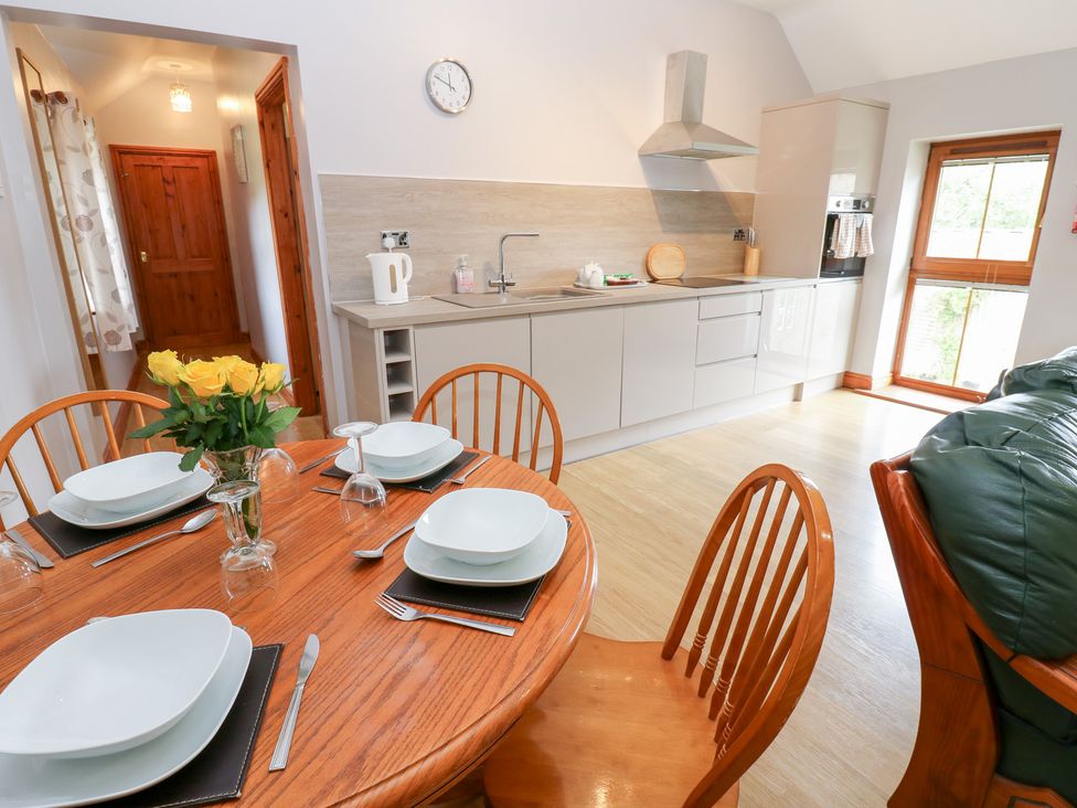 A kitchen with dining area and flowers on the table at The Hayloft in Alston