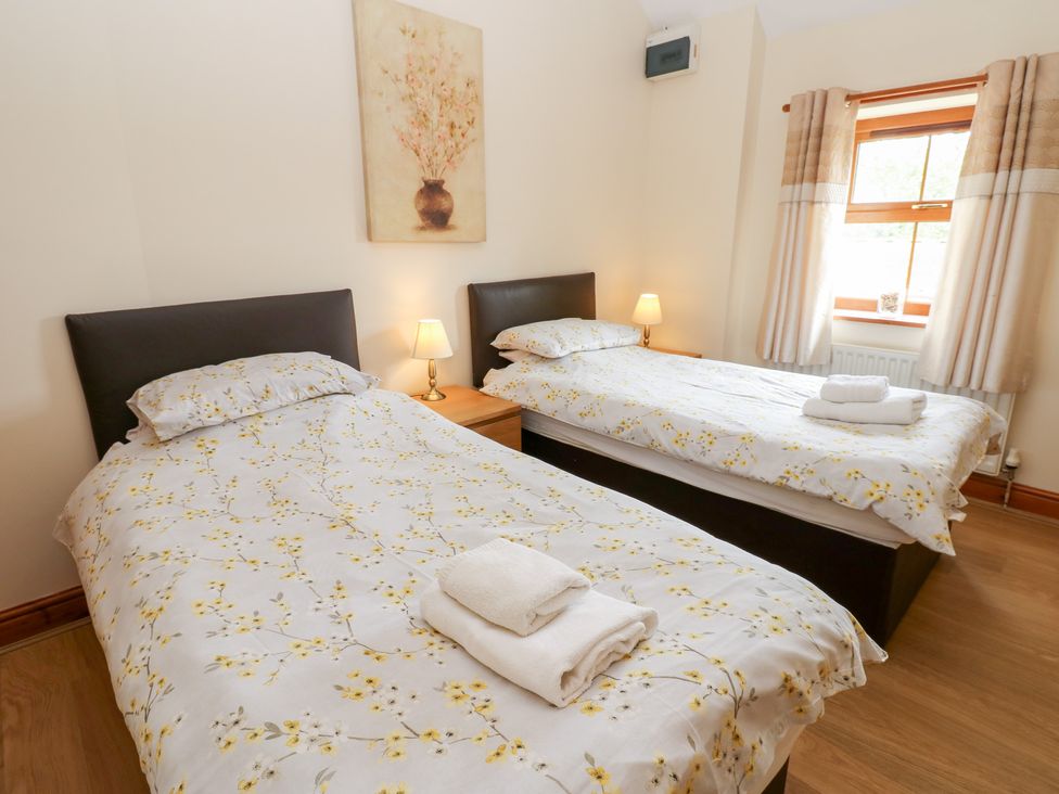 A bedroom with two single beds and a window at The Hayloft in Alston