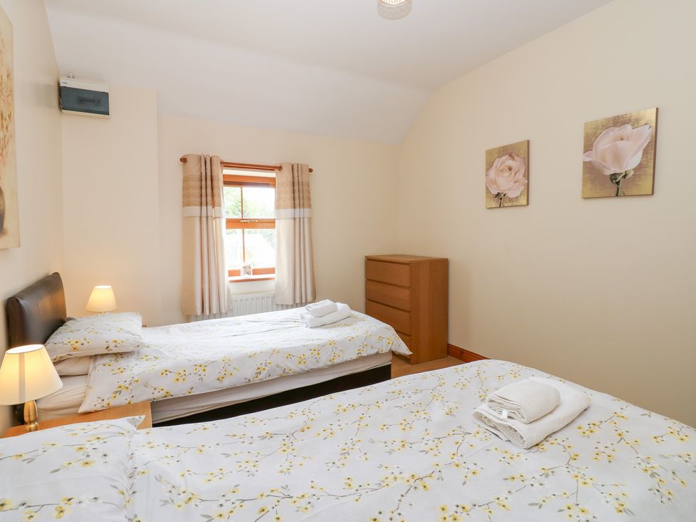 A bedroom with two beds and a chest of drawers at The Hayloft in Alston