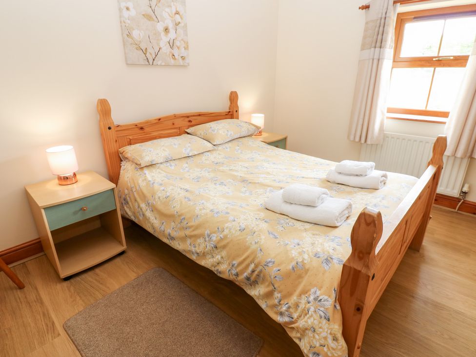 A bedroom with a bed and nightstand at The Hayloft in Alston