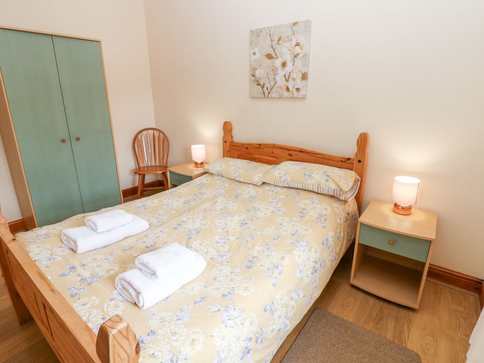 A bedroom with a bed and nightstand at The Hayloft in Alston