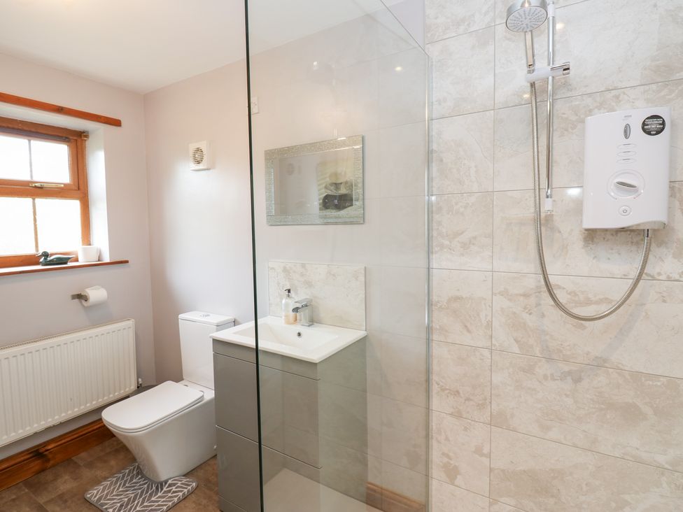 A bathroom with a shower, sink, and toilet at The Hayloft in Alston