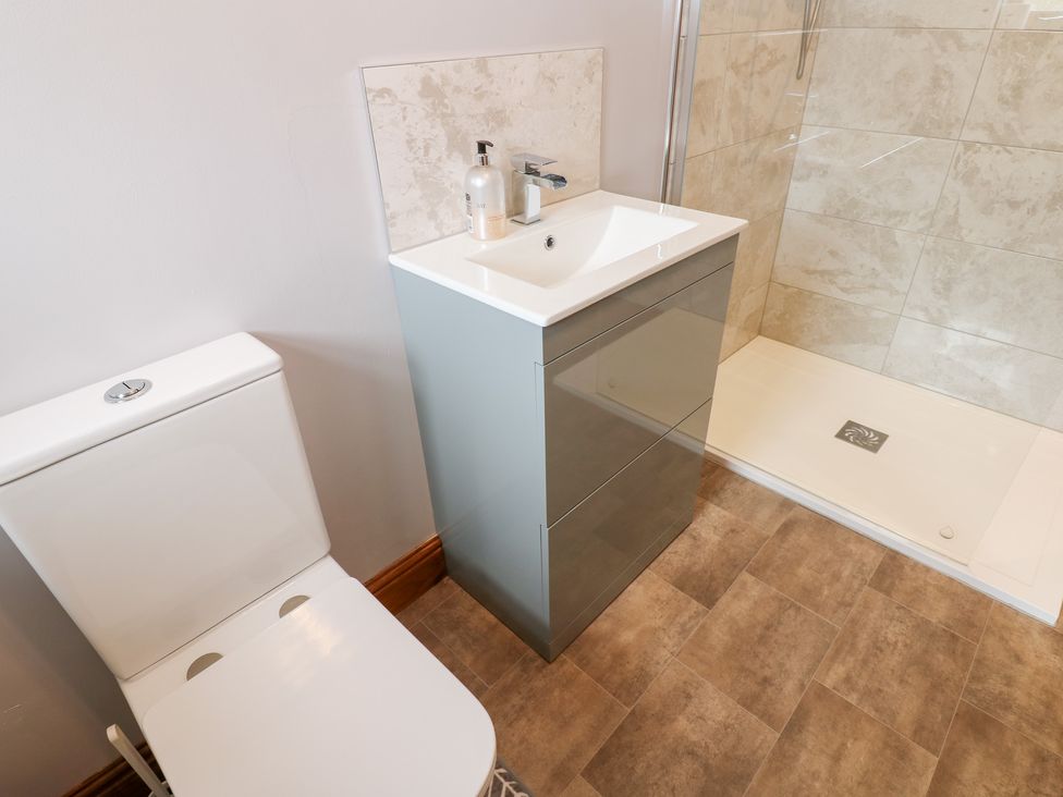 A bathroom with a sink, toilet, and shower at The Hayloft in Alston