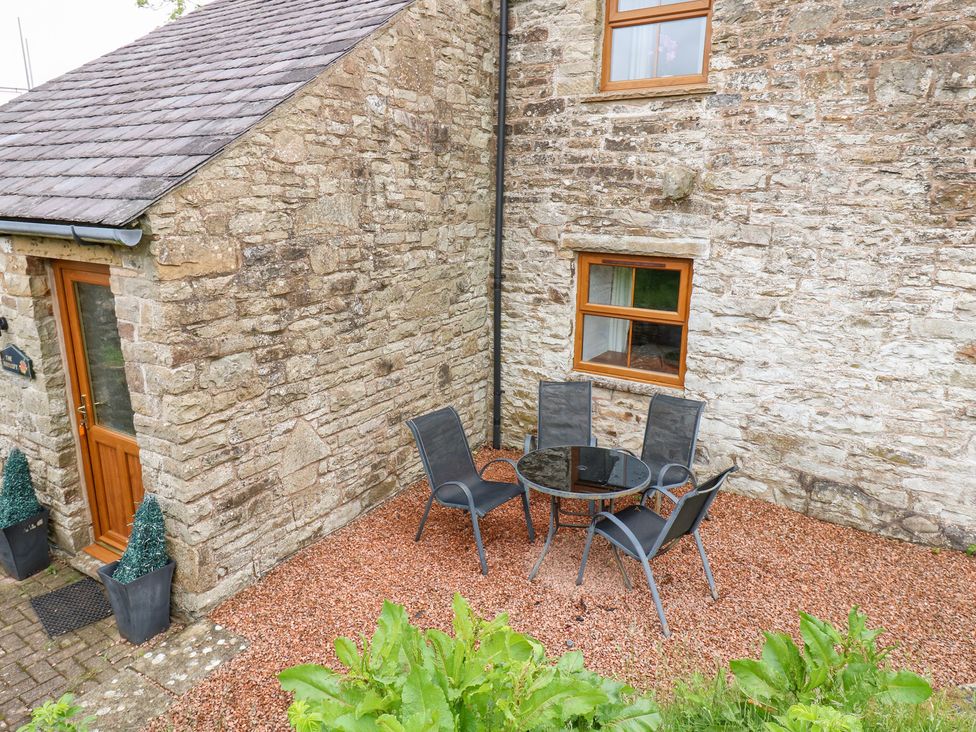 An outdoor seating area with a table and chairs at The Hayloft in Alston
