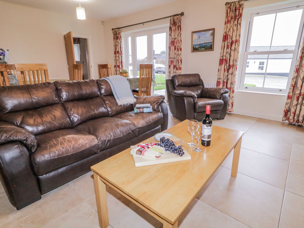 A living room with a coffee table and wine at Foyle Cottage near Strabane
