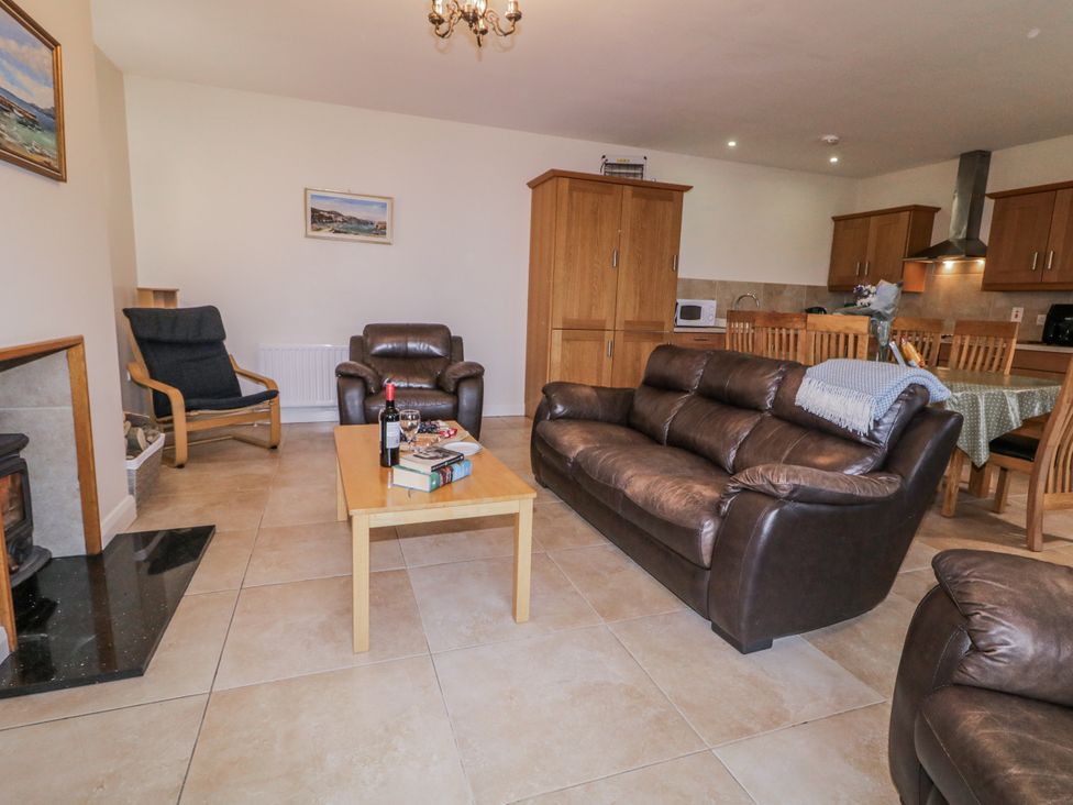 A living room with a sofa and armchair at Foyle Cottage near Strabane