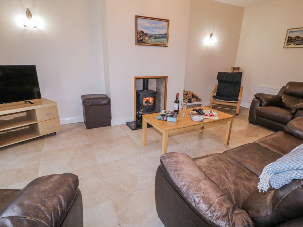 A living room with a television and fireplace at Foyle Cottage near Strabane