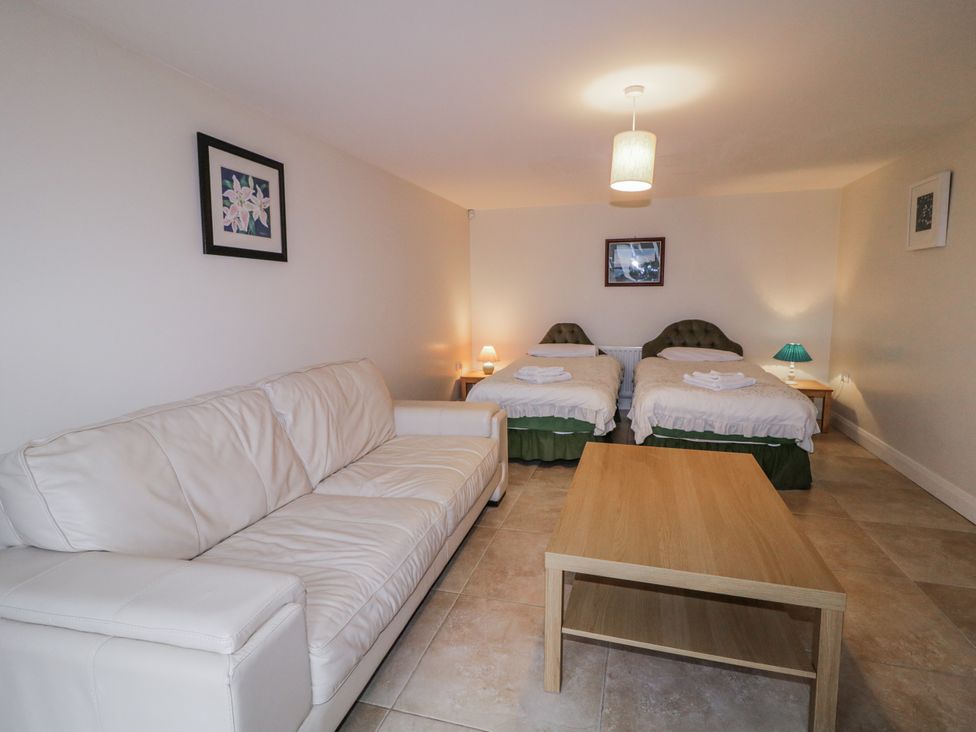 A bedroom with two beds and a sofa at Foyle Cottage near Strabane