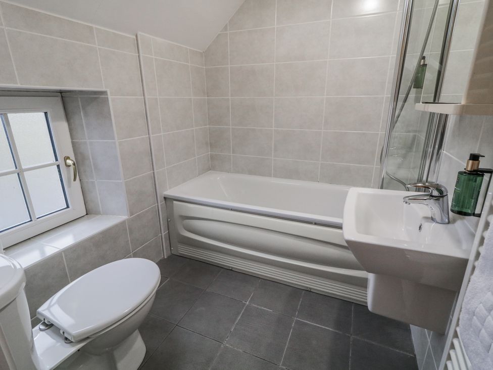 A bathroom with a bathtub, toilet, and sink at Foyle Cottage near Strabane