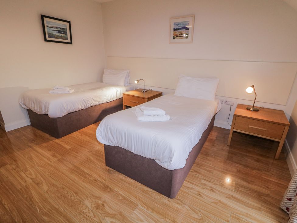 A bedroom with two beds and nightstands at Foyle Cottage near Strabane