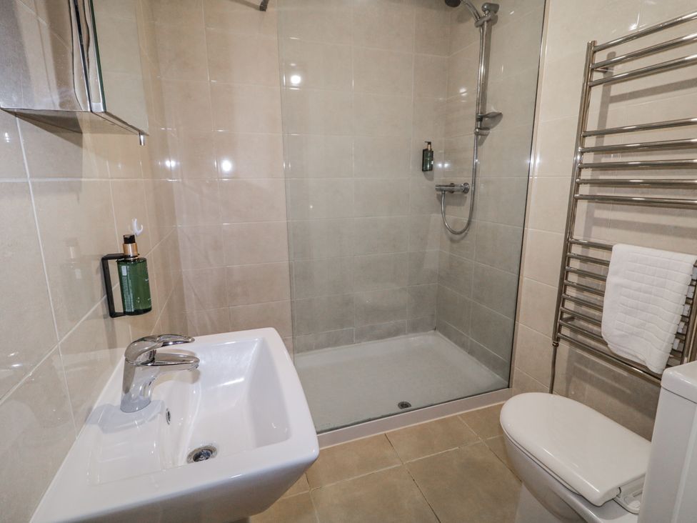 A bathroom with a sink, toilet, and shower at Foyle Cottage near Strabane
