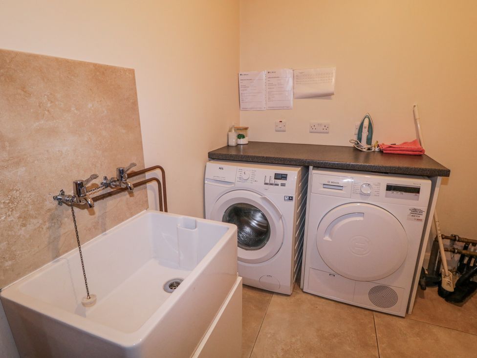 A laundry room with a washing machine and a sink at Foyle Cottage near Strabane