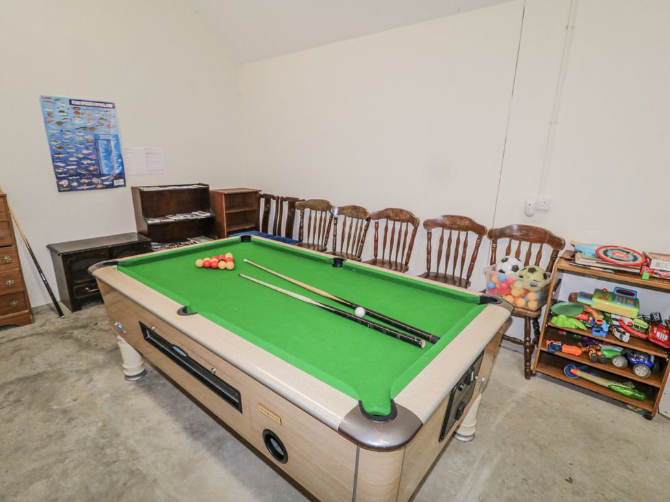 A game room with a pool table and chairs at Foyle Cottage near Strabane