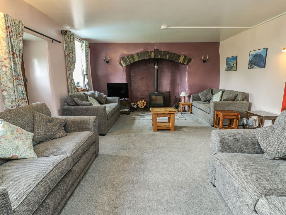 A living room with a fireplace and sofas at Glan y Gors in Dinorwic near Llanberis