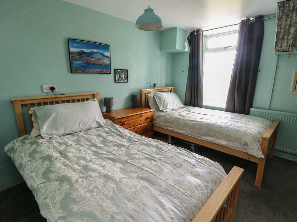 A bedroom with two beds and a window at Glan y Gors in Dinorwic near Llanberis