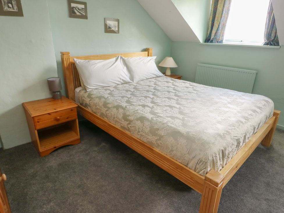 A bedroom with a bed and bedside table at Glan y Gors in Dinorwic near Llanberis