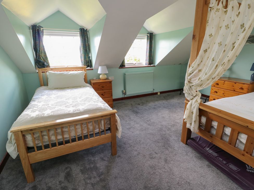 A bedroom with two beds and a lamp at Glan y Gors in Dinorwic near Llanberis
