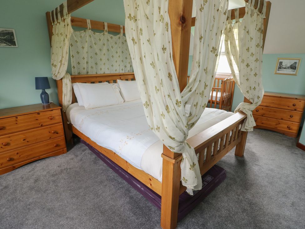 A bedroom with a four-poster bed and dresser at Glan y Gors in Dinorwic near Llanberis