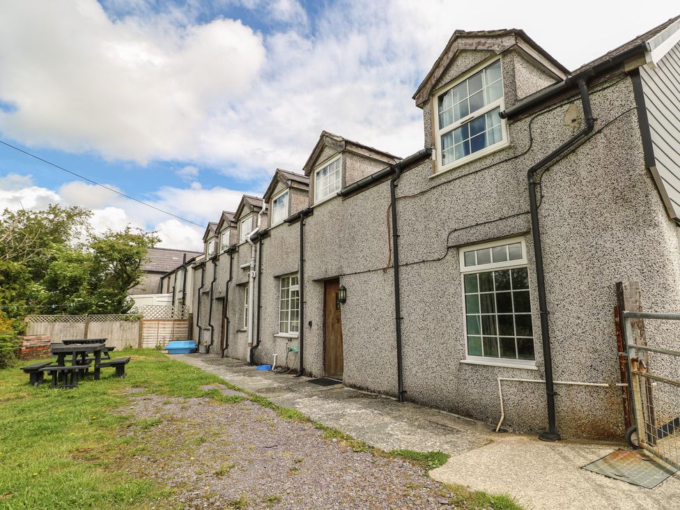 An outdoor area with a building and seating at Glan y Gors in Dinorwic near Llanberis