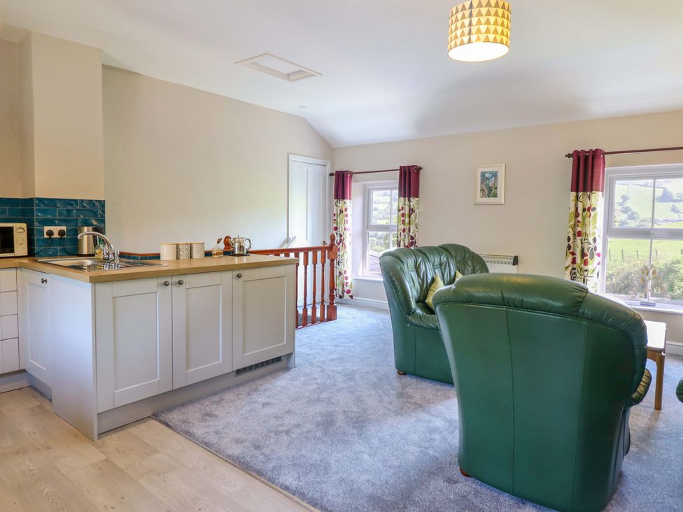 A living room with kitchen area and furniture at Peniarth in Penybontfawr near Oswestry