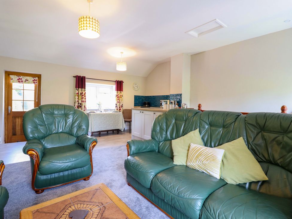 A living room with green sofas and a coffee table at Peniarth in Penybontfawr near Oswestry