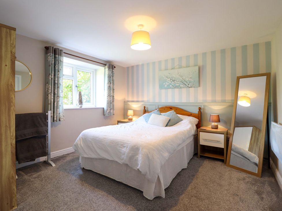 A bedroom with a bed and nightstand at Peniarth in Penybontfawr near Oswestry