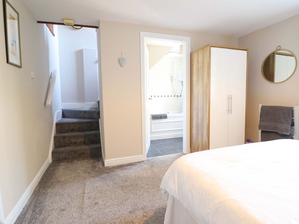 A bedroom with stairs and a bathroom door at Peniarth in Penybontfawr near Oswestry