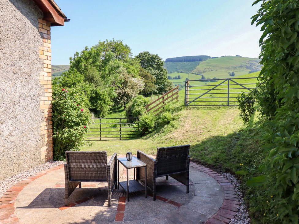 A garden with patio furniture and a view of fields at Peniarth in Penybontfawr near Oswestry