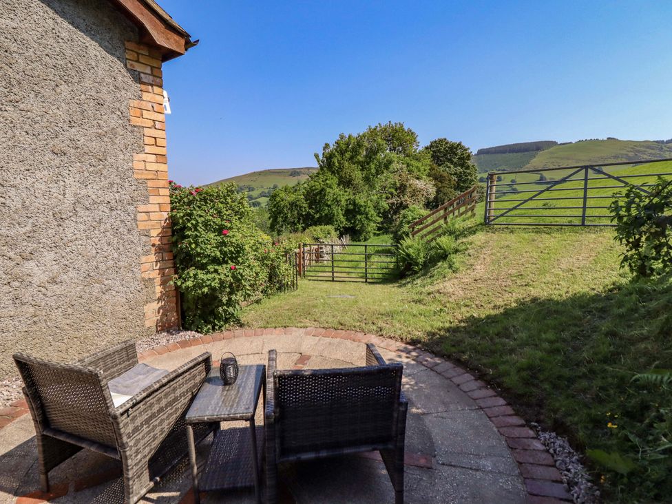 An outdoor area with chairs and a table at Peniarth in Penybonfawr near Oswestry