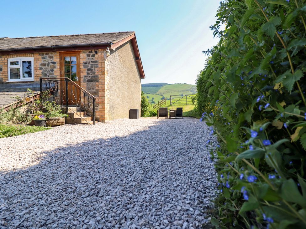 An outdoor area with a house and gravel path at Peniarth in Penybontfawr near Oswestry