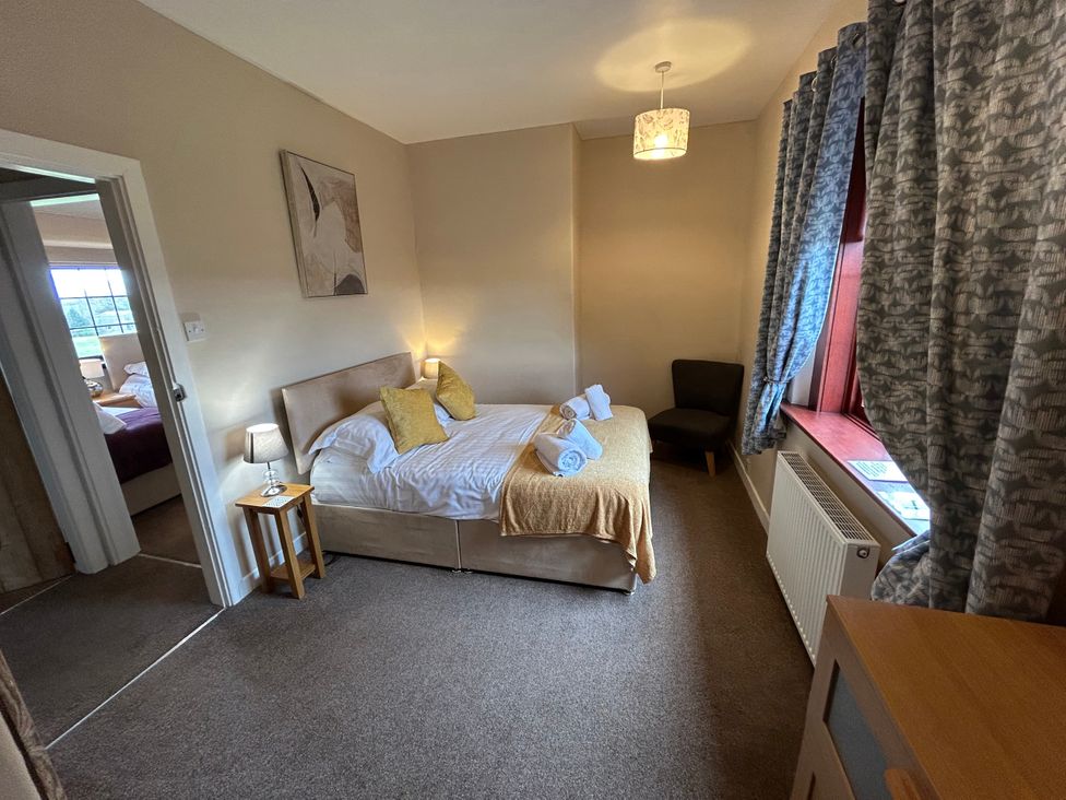A bedroom with a bed and bedside table at Sea Lily New Haggerston near Holy Island