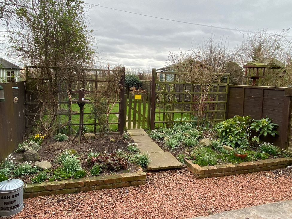 A garden with a pathway and a gate at Sea Lily New Haggerston near Holy Island