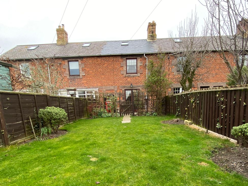 A garden with a pathway and fence at Sea Lily in New Haggerston near Holy Island