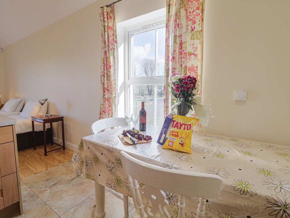 A dining area with a table and snacks at Derg Cottage