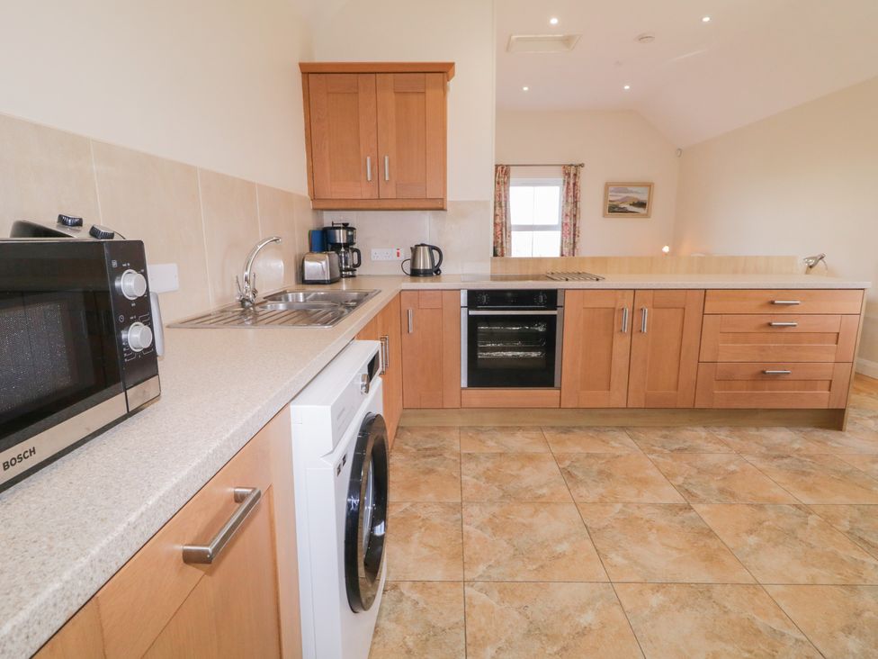 A kitchen with cabinets and appliances at Derg Cottage