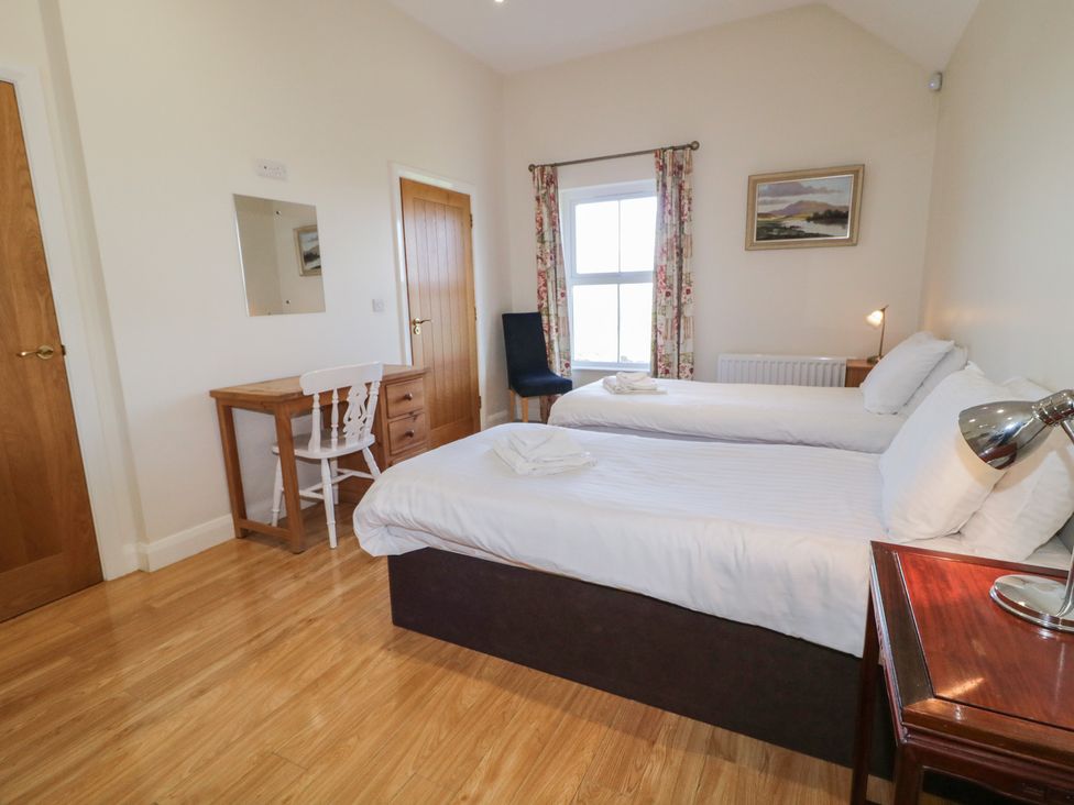 A bedroom with two beds and a table at Derg Cottage 
