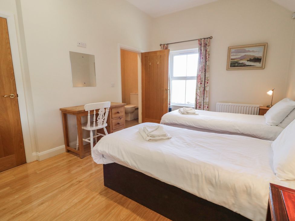 A bedroom with twin beds and a desk at Derg Cottage in 